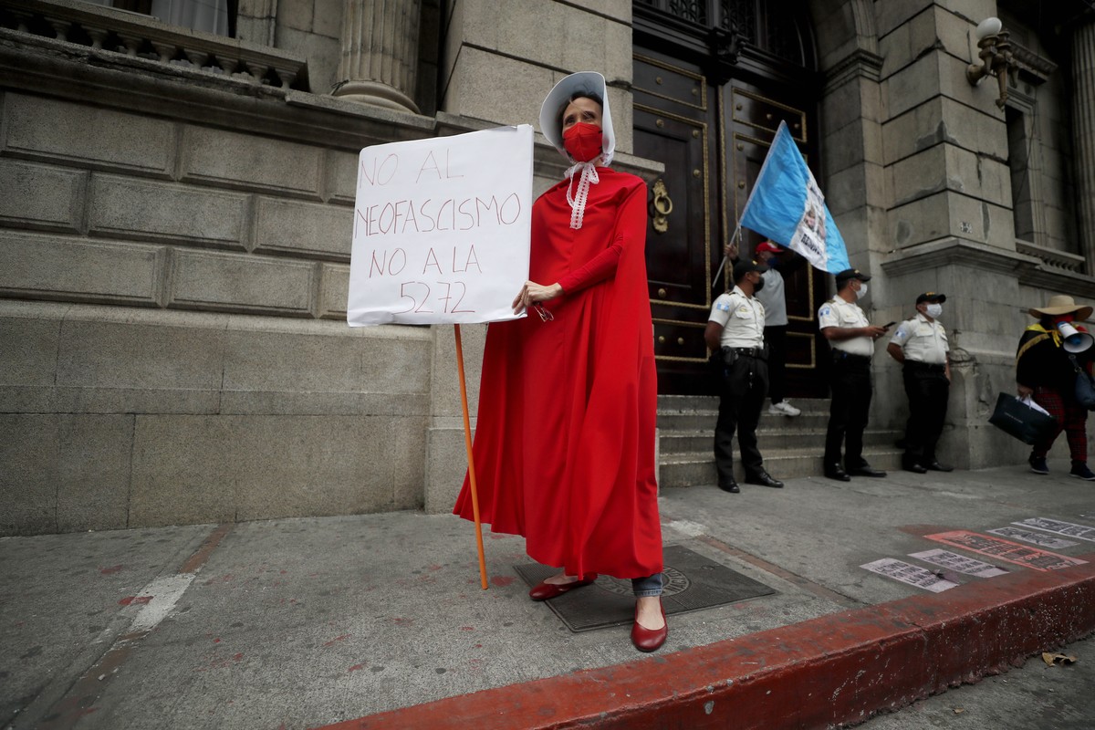 epa09819894 A woman in front of the Guatemalan Congress dressed as a character of the book and the television series The Handmaid's Tale holds a banner that reads 'No to Neofascism, no to 57 ...