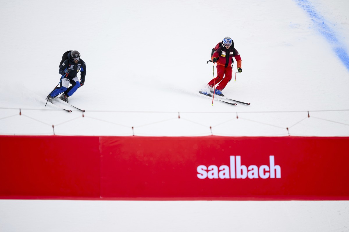France's Cyprien Sarrazin, left, and Switzerland's Marco Odermatt ski down the slope after the alpine ski men's World Cup downhill race was cancelled due to poor weather conditions, in  ...
