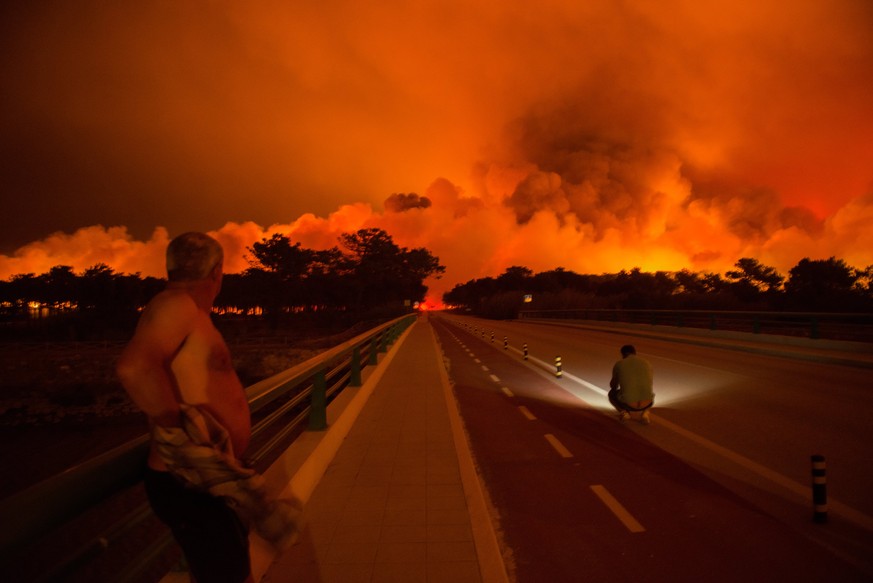 JAHRESRUECKBLICK 2017 - INTERNATIONAL - epa06268326 Residents looks to the fire in Praia da Vieira, Marinha Grande, Portugal, 15 October 2017. The National Civil Protection Authority (ANPC) said that  ...