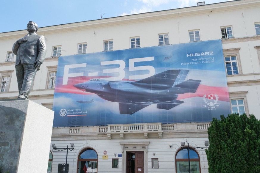 June 12, 2026, Warsaw, Masovian Voivodeship, Poland: A large sign showing a Polish F-35 jet hangs on the facade of the Warsaw Garrison Command building, behind the statue of Lech Kaczynski, shortly af ...