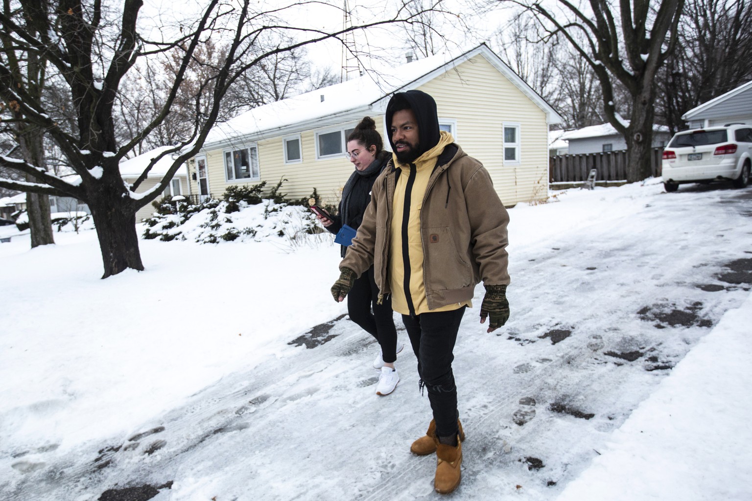 In this Friday, Jan. 24, 2020, photo, Phillip Agnew knocks on doors for Democratic presidential candidate, Sen. Bernie Sanders, I-Vt., before the Iowa caucus, in Iowa City, Iowa. (Joseph Cress/Iowa Ci ...