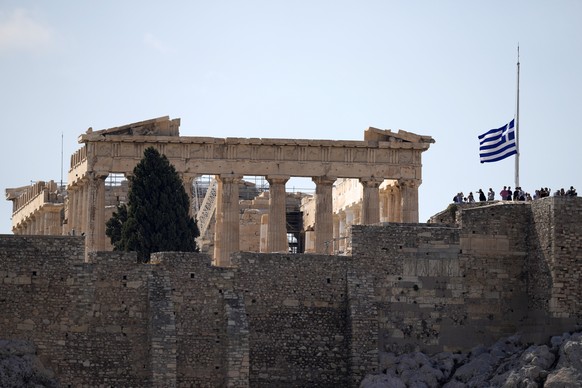 The Greek flag flies at half-mast in front of the Parthenon temple after the death of Greek composer Mikis Theodorakis in Athens, Greece, Thursday, Sept. 2, 2021. Mikis Theodorakis, the beloved Greek  ...