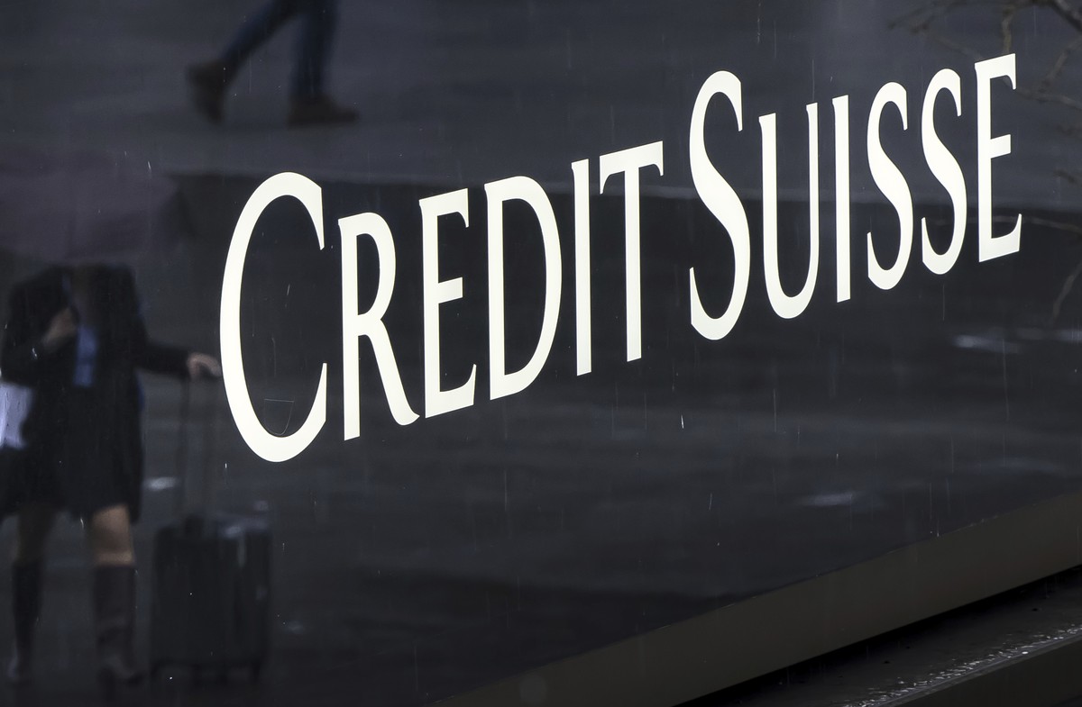A woman walks past a logo of the Swiss bank Credit Suisse in Zurich, Switzerland, Friday, March 24, 2023. (Michael Buholzer/Keystone via AP)