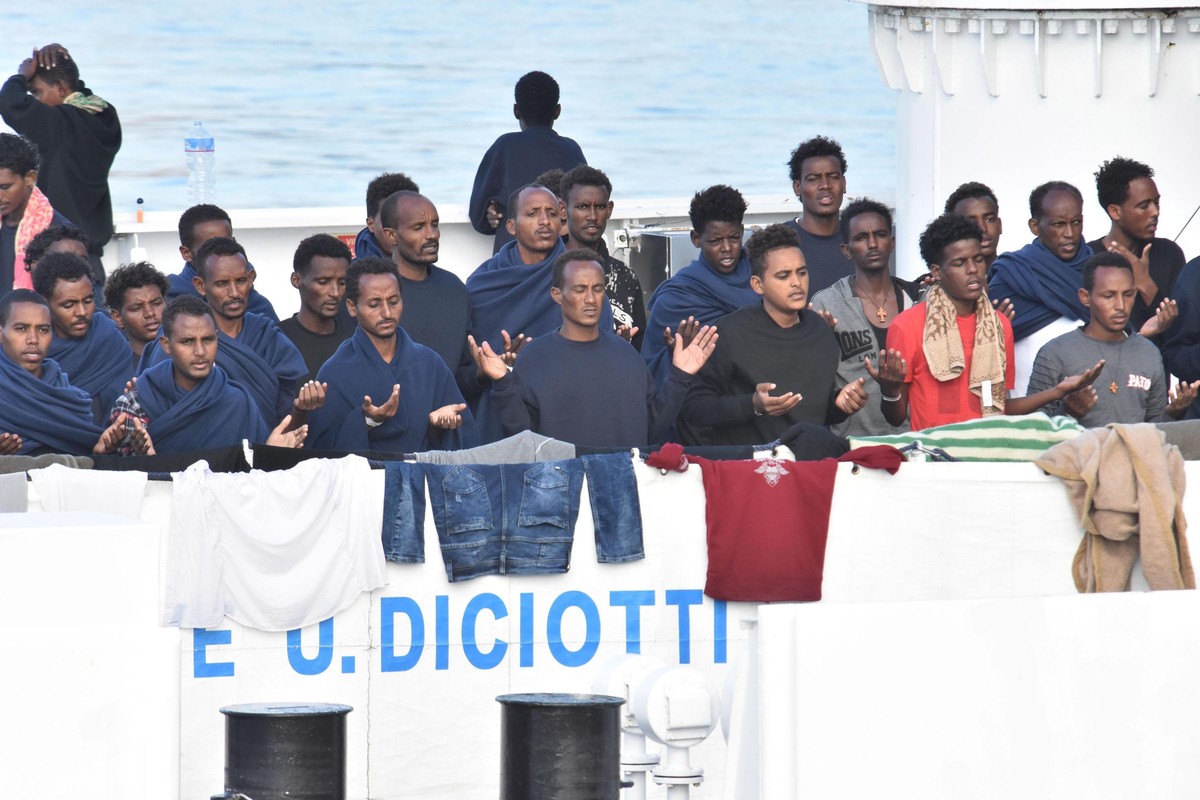 epaselect epa06963777 Migrants pray as they wait to disembark from Italian Coast Guard ship Diciotti in the port of Catania, Italy, 22 August 2018. Italian Interior Minister Matteo Salvini said on 20  ...
