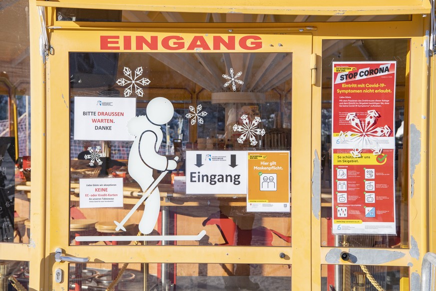 Die Restaurants an den Stationen duerfen Take Away Essen und Getraenke verkaufen. Skifahrer geniessen den schoenen aber kalten Wintertag auf den Skipisten von Soerenberg im Kanton Luzern unter den Cor ...