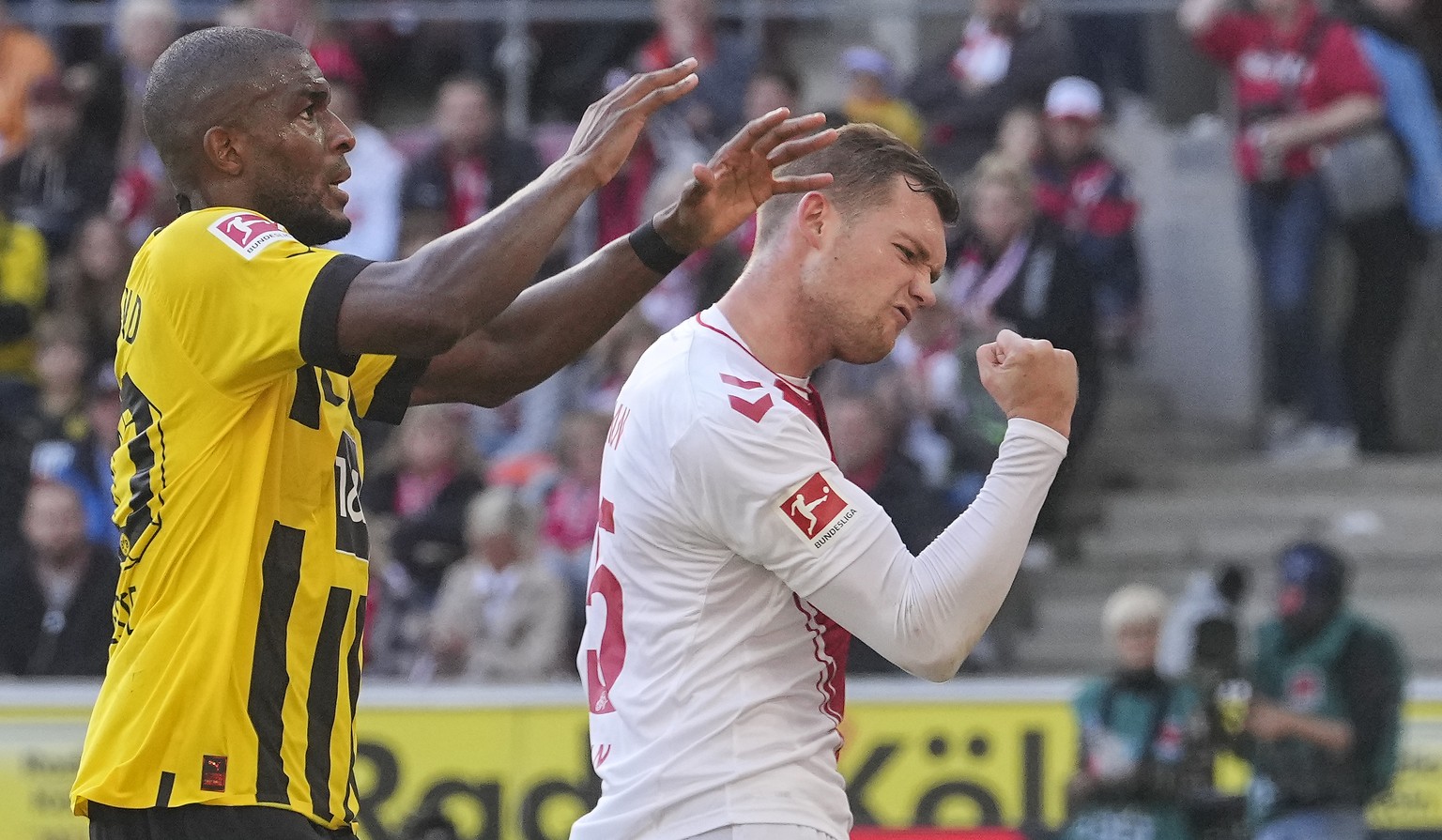 Cologne&#039;s Luca Kilian, right, reacts after winning a fight for the ball against Dortmund&#039;s Anthony Modeste, left, during the German Bundesliga soccer match between 1.FC Cologne and Borussia  ...