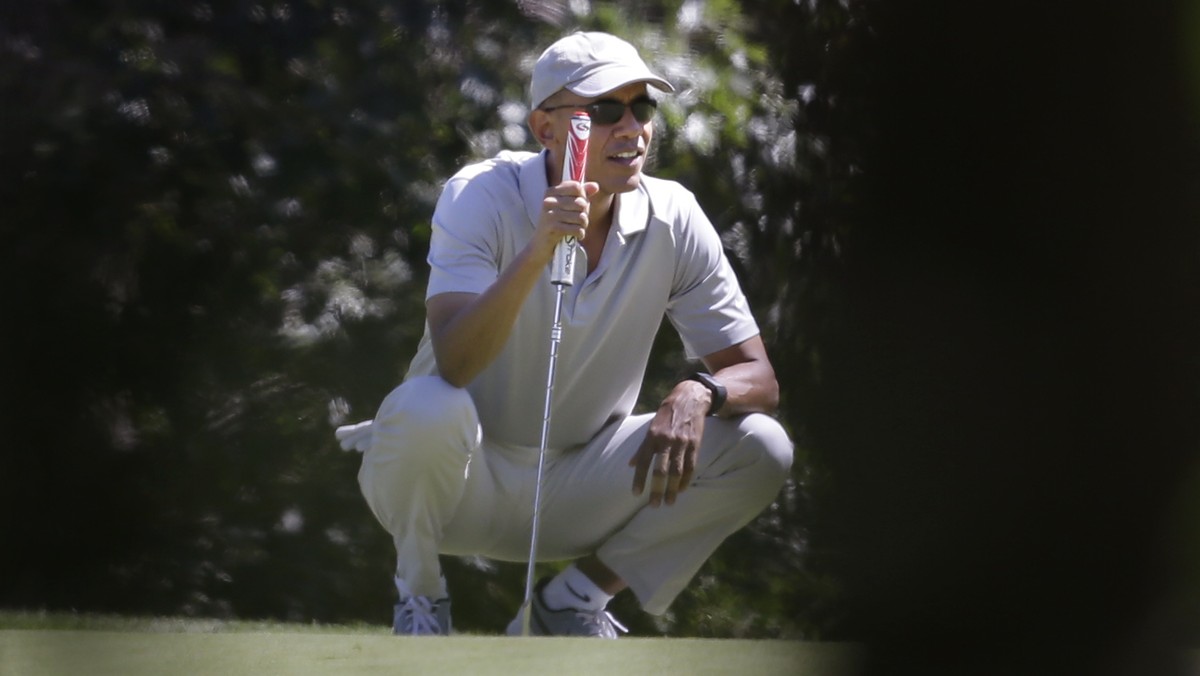 President Barack Obama holds a golf club as he squats down near a green while golfing Saturday, Aug. 8, 2015, at Farm Neck Golf Club, in Oak Bluffs, Mass., on the island of Martha's Vineyard. Oba ...