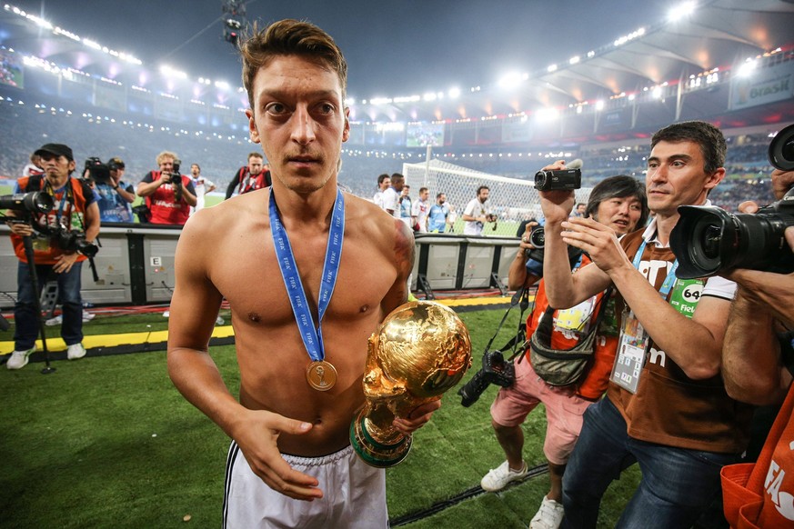 Football - 2014 FIFA World Cup, WM, Weltmeisterschaft, Fussball - Final - Germany v Argentina 13 July 2014 - FIFA World Cup - Final - Germany v Argentina - Mesut Ozil of Germany holds the world cup tr ...