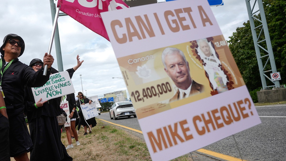 A sign with a photo of Air Canada CEO Michael Rousseau on it is seen as striking Air Canada flight attendants rally at Vancouver International Airport, in Richmond, British Columbia, Monday, Aug. 18,  ...