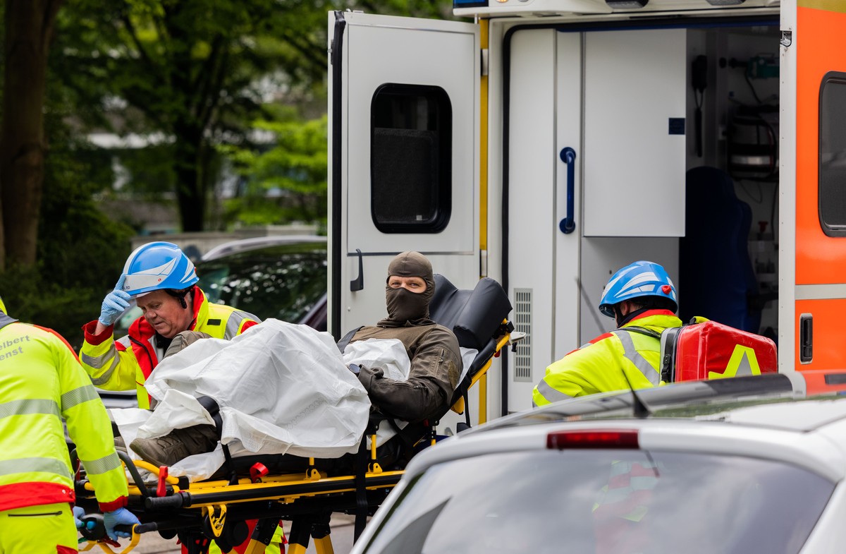 11.05.2023, Nordrhein-Westfalen, Ratingen: Ein verletzter Polizeibeamter wird vor einem Hochhaus in einen Krankenwagen gebracht. Bei einer Explosion in einem Hochhaus in Ratingen am Donnerstagvormitta ...