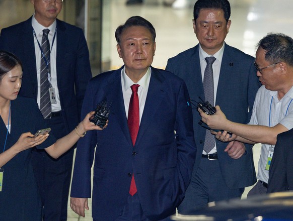 epa12228130 Former South Korean President Yoon Suk Yeol (C), exits the Seoul Central District Court after attending a hearing to review the legality of his detention over charges related to his failed ...