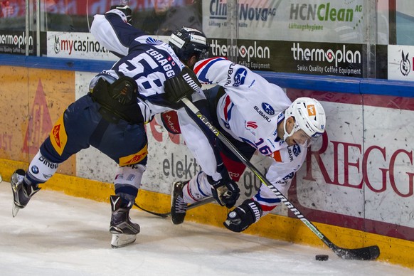 EV Zug Verteidiger Jesse Zgraggen, links, gegen ZSC Lions Stuermer Marcus Krueger waehrend dem Eishockey-Meisterschaftsspiel der National League zwischen dem EV Zug und den ZSC Lions am Freitag, 22. N ...