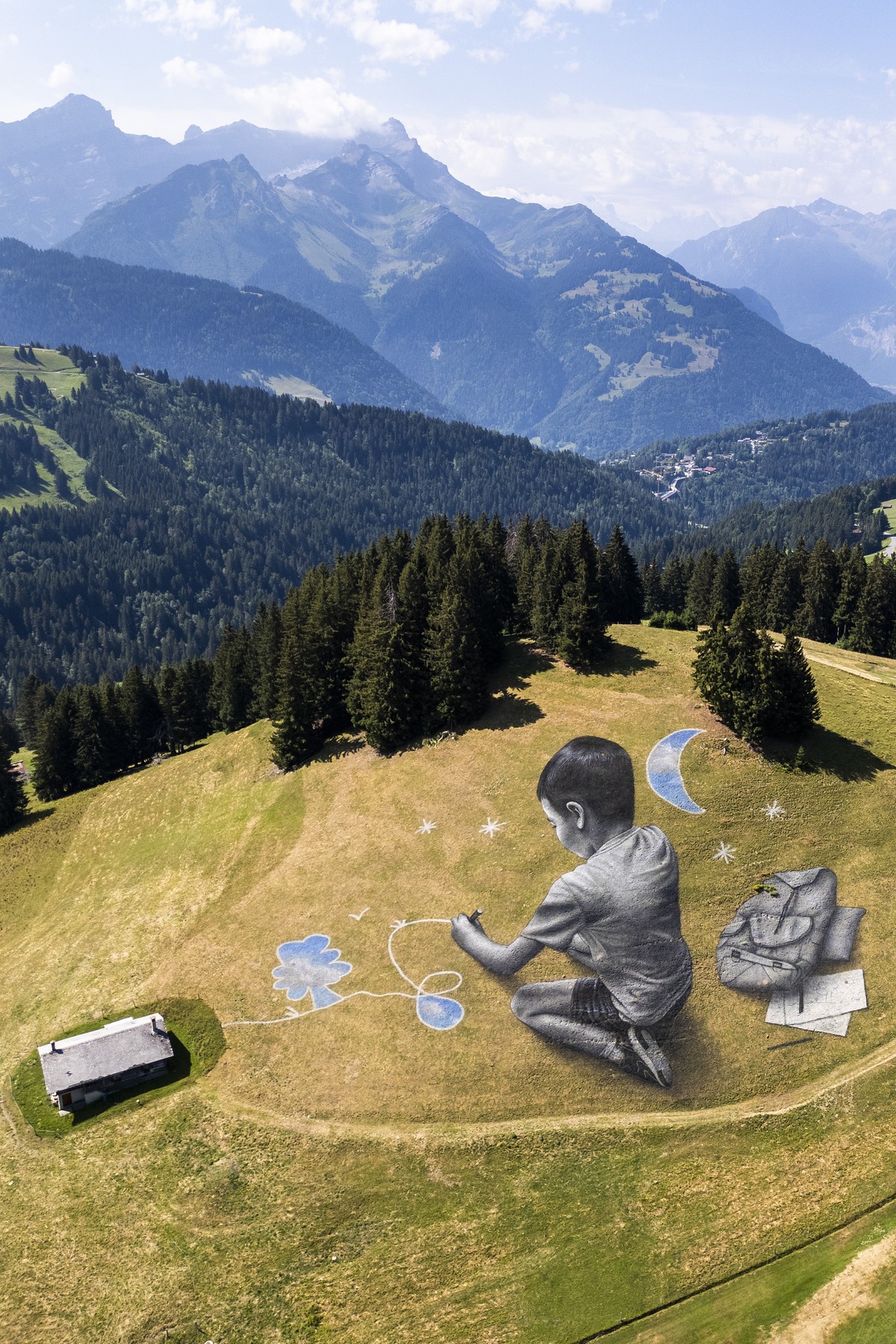 A drone view shows a giant biodegradable land art called "A portee de ciel" painting by French-Swiss artist Saype at the Villars Golf Club, in Villars-sur-Ollon, Switzerland, Tuesday, July 2 ...