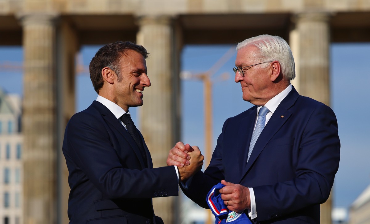 epa11372182 German President Frank-Walter Steinmeier (R) and French President Emmanuel Macron (L) pose for photos in front of Brandenburg gate, during the kick off of the German-French sport summer at ...