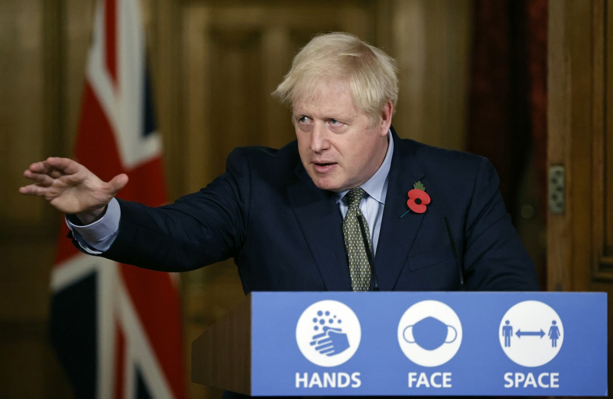 Britain's Prime Minister Boris Johnson reaches out during a virtual press conference on the coronavirus pandemic at 10 Downing Street in central London Monday Nov. 9, 2020. Johnson gave some deta ...