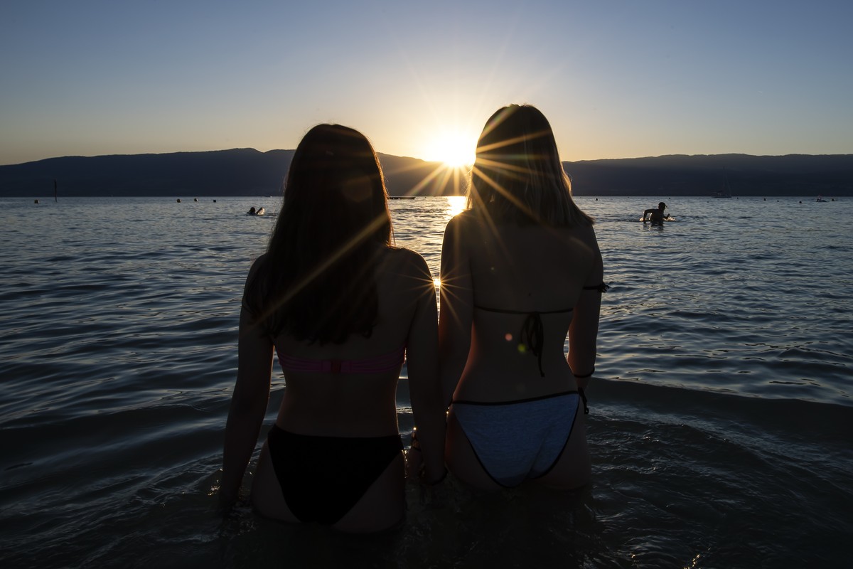Two teenage girls enjoy the sunset in the water of the Lac de Neuchatel to cool off during the sunny and warm weather, in Gletterens, Switzerland, Friday, June 28, 2019. The forecast predicts hot weat ...