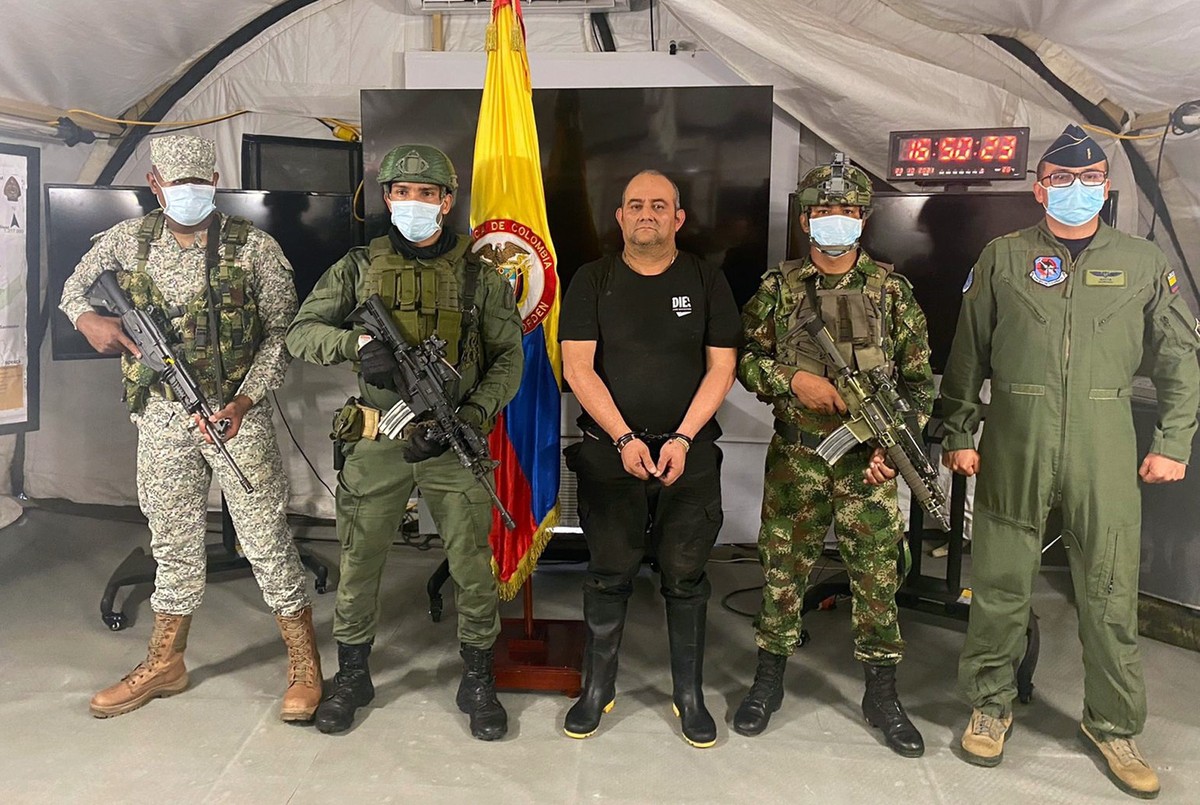 epa09542377 A handout photo made available by the Colombian Presidency that shows the number one criminal gang of the 'Clan del Golfo' criminal band, Dairo Antonio Usuga David (C), alias   ...