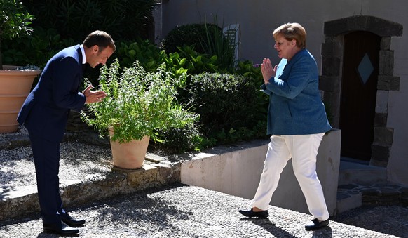 epa08614748 French President Emmanuel Macron (L) welcomes German Chancellor Angela Merkel (R), as she arrives at Fort de Bregancon, in Bormes-les-Mimosas, south-east of France, 20 August 2020. French  ...