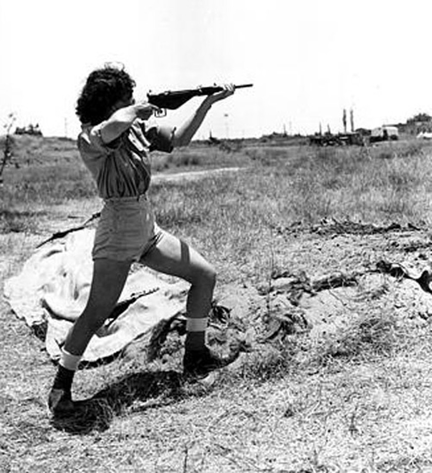 Eine Offizierin der Hagana demonstriert den Einsatz einer Maschinenpistole.