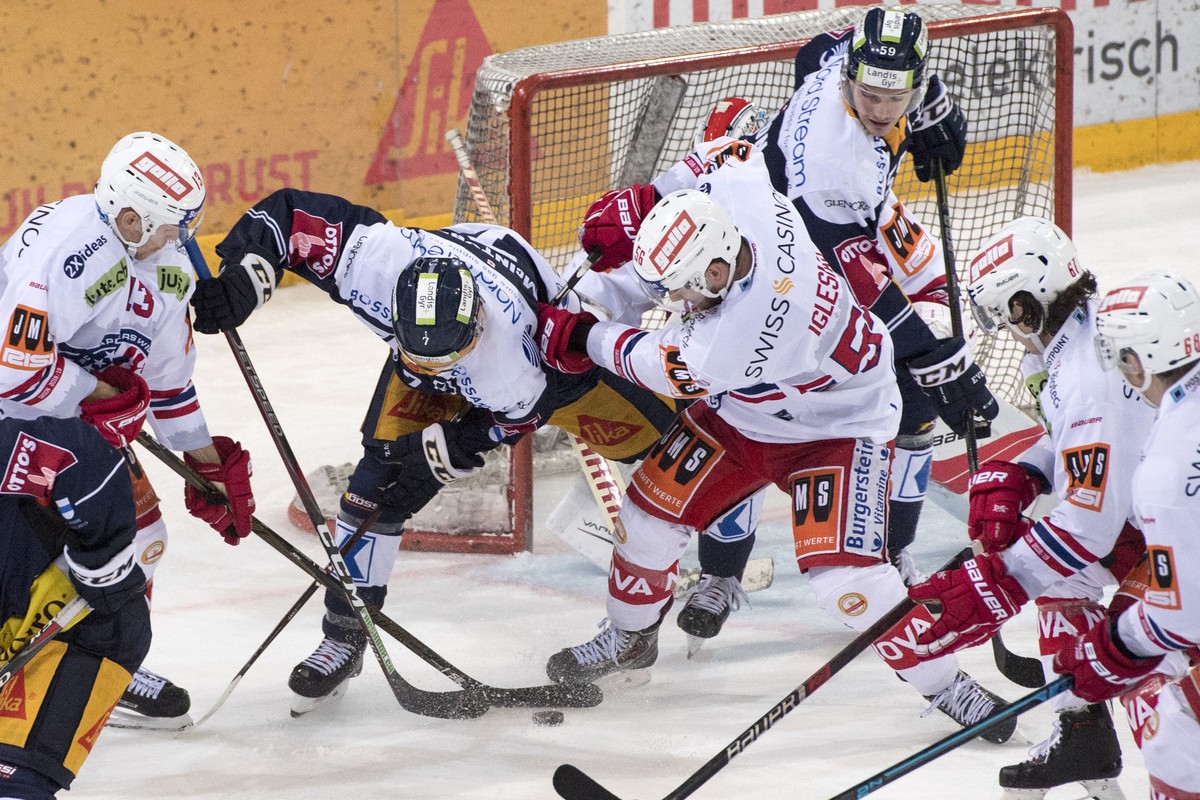 David McIntyre, mitte links, von Zug im Spiel gegen Frederic Iglesias, mitte rechts, von Rapperswil beim Eishockey Meisterschaftsspiel in der Qualifikation der National League zwischen dem EV Zug und  ...