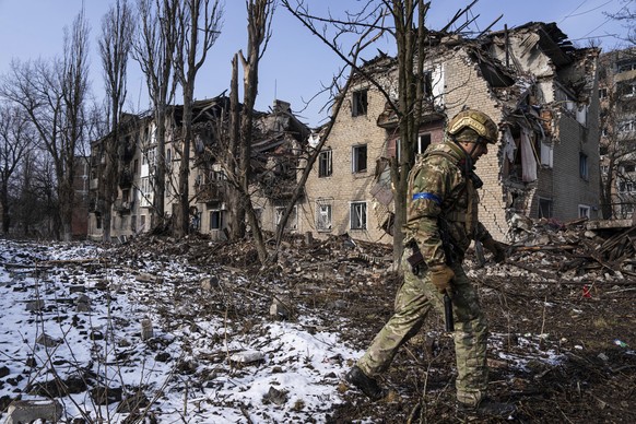 A police officer walks in front of the residential building which was destroyed by a Russian attack, in Avdiivka, Ukraine, Tuesday, March 7, 2023. (AP Photo/Evgeniy Maloletka)