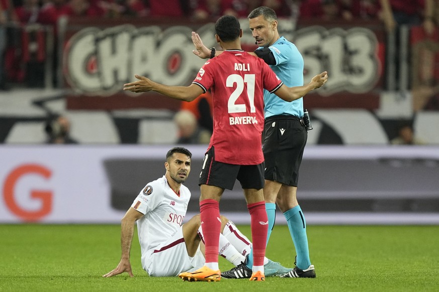 Roma&#039;s Zeki Celik sits on the ground as Leverkusen&#039;s Amine Adli talks to the referee during the Europa League semifinal second leg soccer match between Bayer Leverkusen and Roma at the BayAr ...