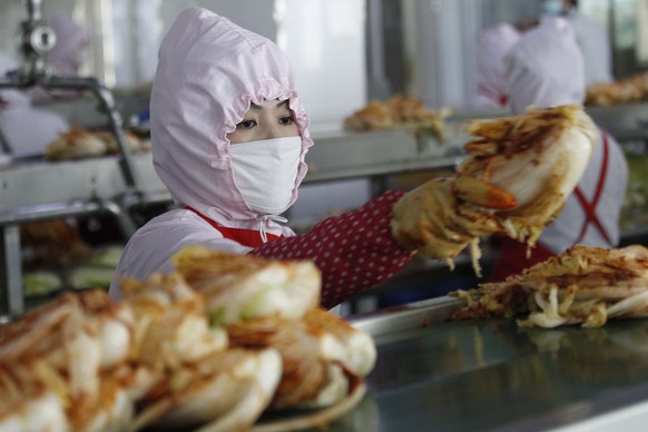 Workers of the Ryugyong Kimchi factory make fresh kimchi on Tuesday, Dec., 1, 2020, in Pyongyang, North Korea. (AP Photo/Cha Song Ho)