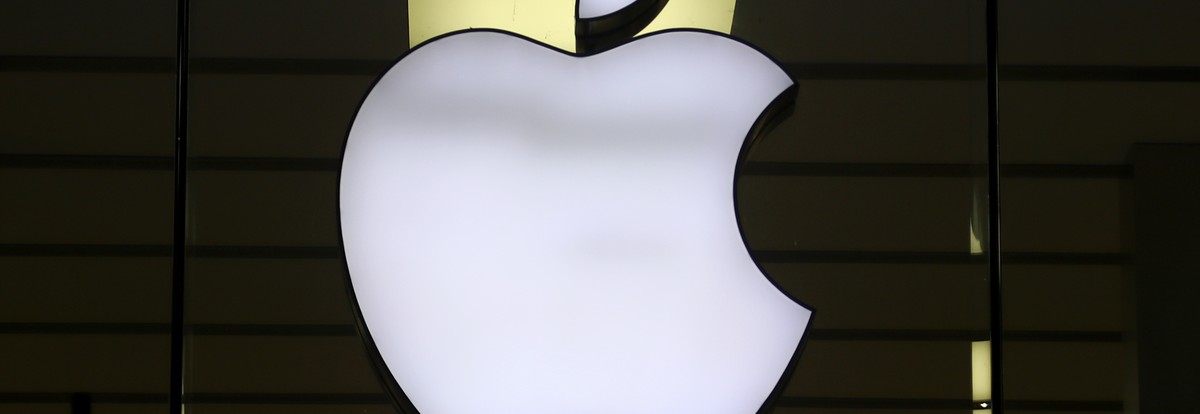 FILE - The logo of Apple is illuminated at a store in the city center in Munich, Germany, on Dec. 16, 2020. Italy's antitrust watchdog has fined Apple and Amazon more than 200 million euros ($225 ...