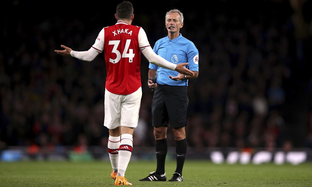 Arsenal's Granit Xhaka speaks to referee Martin Atkinson during the English Premier League soccer match at the Emirates Stadium, London, Sunday Oct. 27, 2019. (Nigel French/PA via AP)