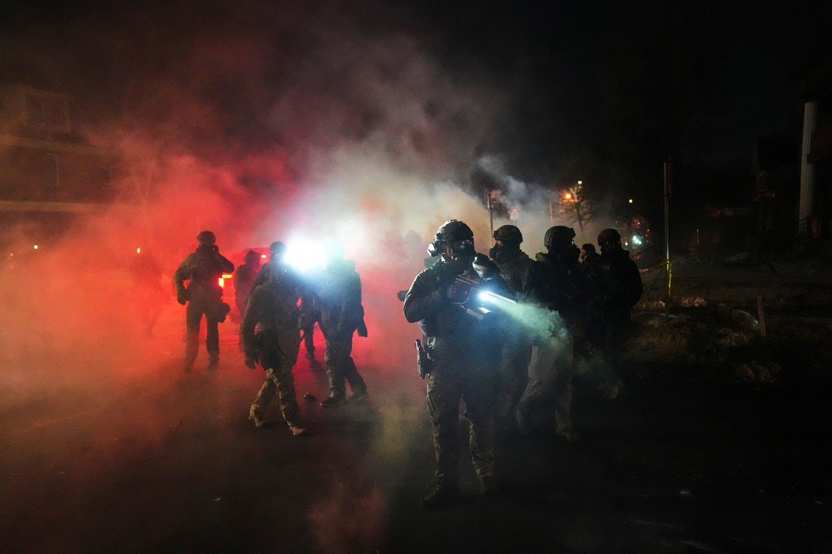 KEYPIX - Law enforcement officers stand amid tear gas at the scene of a reported shooting Wednesday, Jan. 14, 2026, in Minneapolis. (AP Photo/Adam Gray)