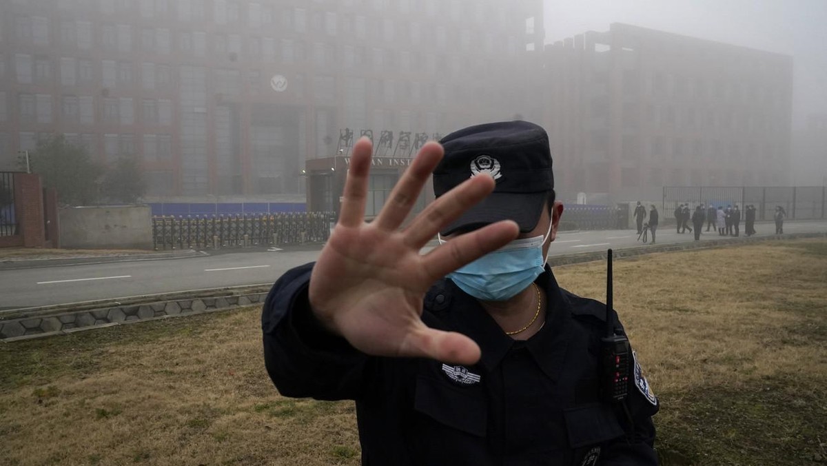 Un agent de sécurité éloigne des journalistes de l'Institut de virologie de Wuhan après l'arrivée d'une équipe de l'Organisation mondiale de la santé pour une visite sur le terrain ...