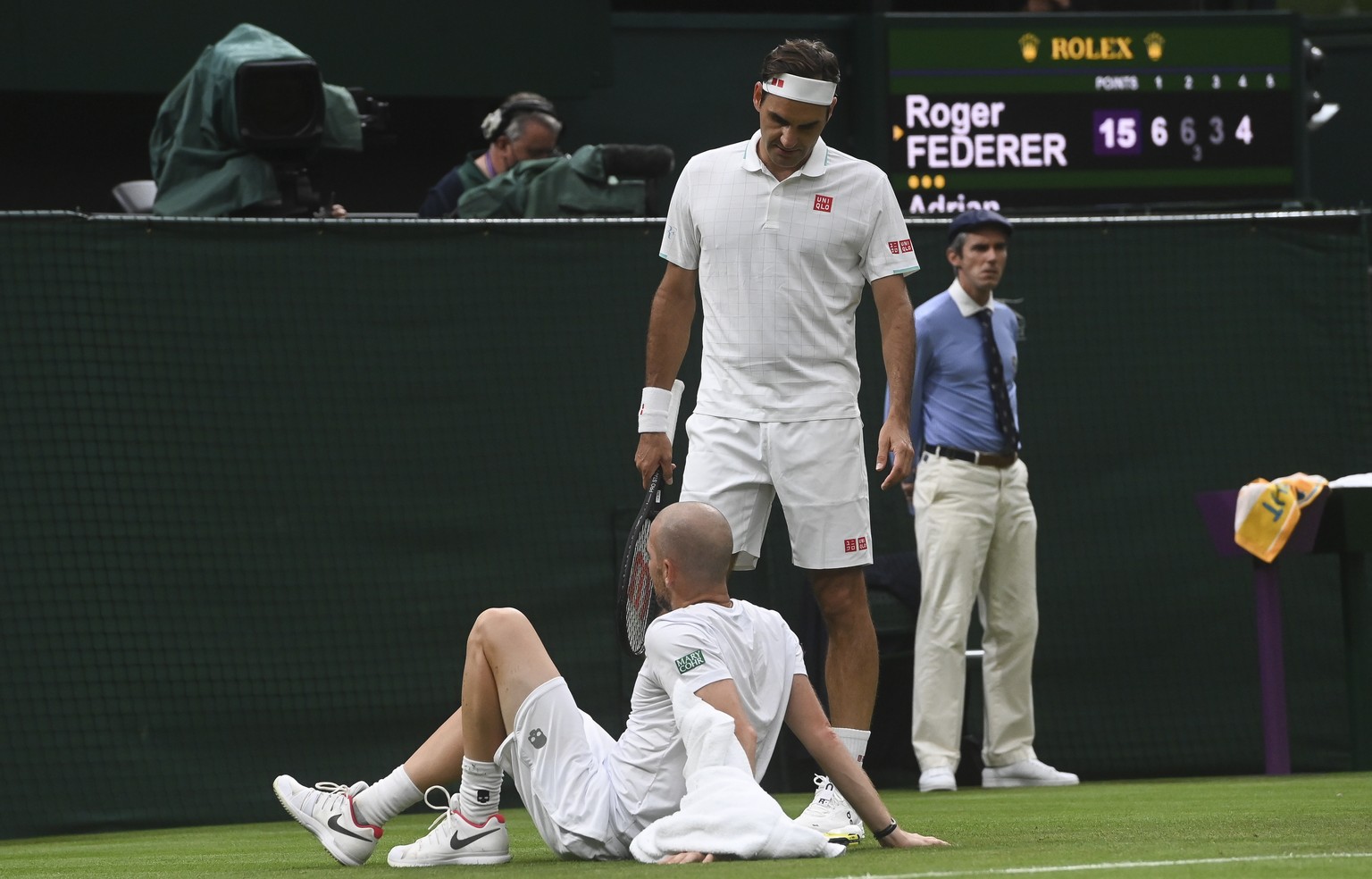 epa09311576 Adrian Mannarino (down) of France reacts during his first round match against Roger Federer (up) of Switzerland at the Wimbledon Championships tennis tournament in Wimbledon, Britain, 29 J ...