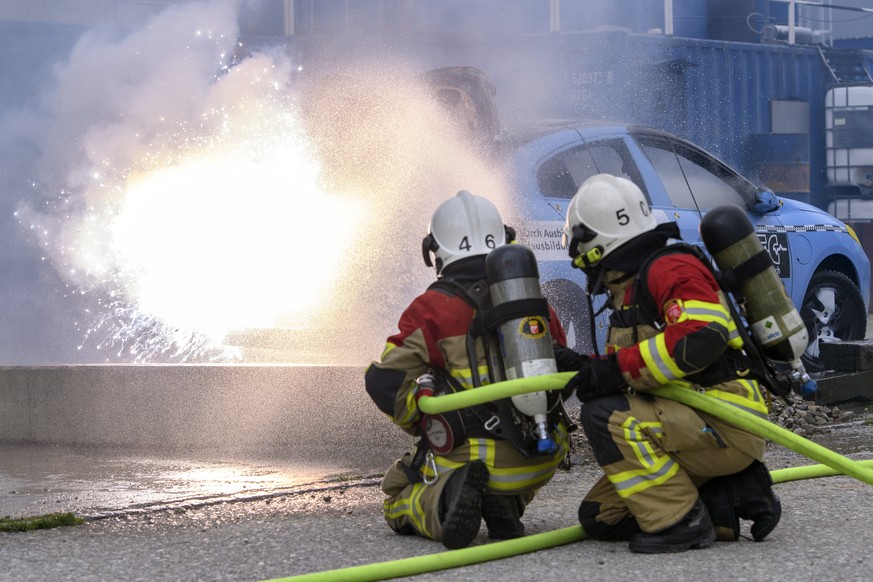 Des pompiers de la ville de Bienne eteignent une voiture electrique en feu lors du Baloise Car Crashtest de vehicules electriques, ce jeudi, 5 avril 2018, au Ausbildungszentrum fuer Sicherheit Afs, a  ...
