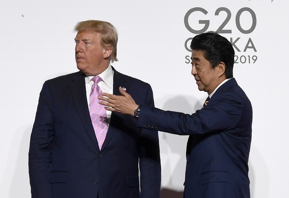 President Donald Trump and Japanese Prime Minister Shinzo Abe gesture for Ivanka Trump and her husband senior adviser Jared Kushner to join them for a photo during a meeting on the sidelines of the G- ...