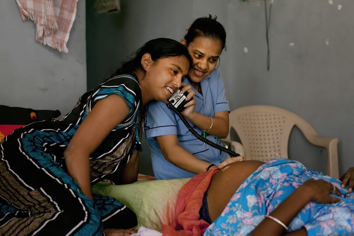 In this Nov. 3, 2015 photo, a nurse and a surrogate mother listen to a baby's heartbeat in a dormitory run by Akanksha Clinic, one of the most organized clinics in the surrogacy business, in Anan ...
