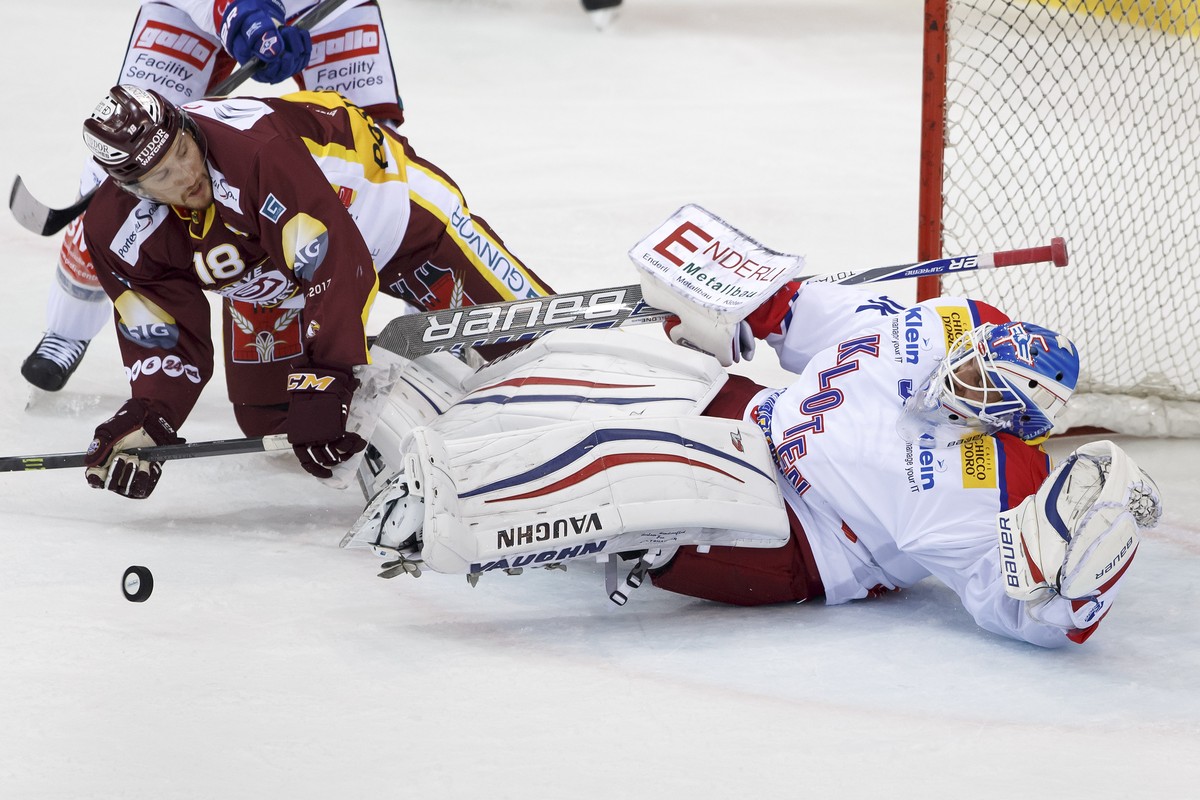 Kloten's goaltender Luca Boltshauser, right, saves a puck past Geneve-Servette's forward Jeremy Wick, left, during the game of National League A (NLA) Swiss Championship between Geneve-Serve ...