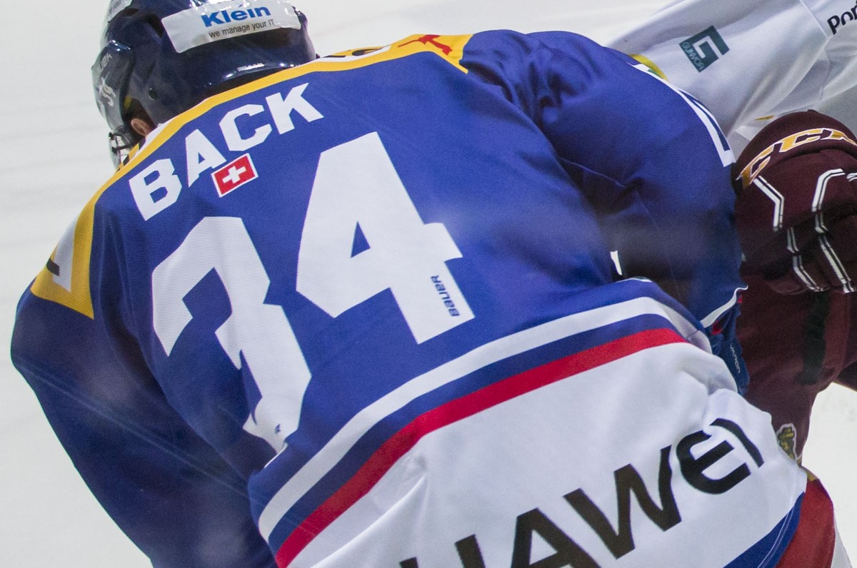 Geneve-Servette HC Stuermer Makai Holdener, rechts, checkt EHC Kloten Verteidiger Rene Back waehrend dem Eishockey-Meisterschaftsspiel der National League zwischen dem EHC Kloten und Geneve-Servette H ...