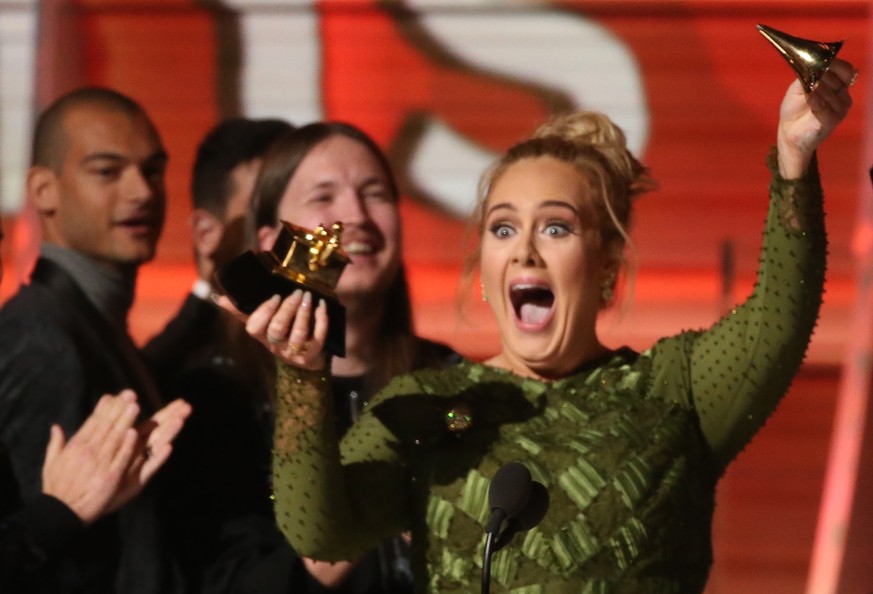Adele breaks the Grammy for Record of the Year for &quot;Hello&quot; after having it presented to her at the 59th Annual Grammy Awards in Los Angeles, California, U.S., February 12, 2017. REUTERS/Lucy ...