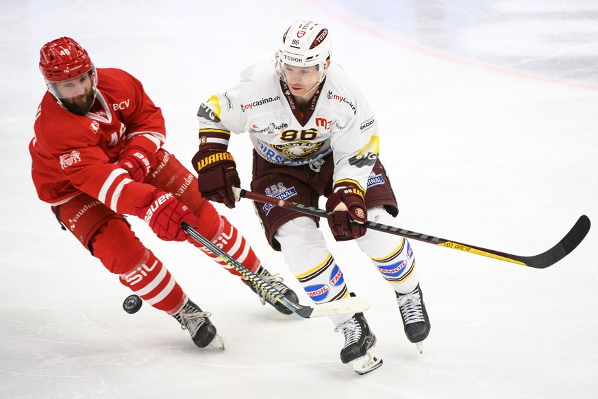 L&#039;attaquant lausannois Benjamin Antonietti, gauche, lutte pour le puck avec l�attaquant genevois Joel Vermin, droite, lors du match a huis clos du championnat suisse de hockey sur glace de Nation ...