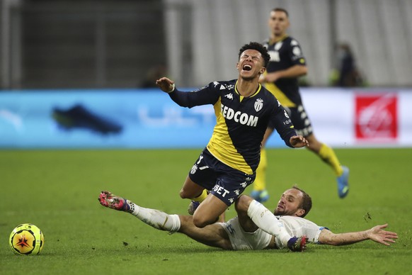 Monaco&#039;s Sofiane Diop reacts as he is tackled by Marseille&#039;s Valere Germain, right, during the French League One soccer match between Marseille and Monaco at the Stade Velodrome in Marseille ...