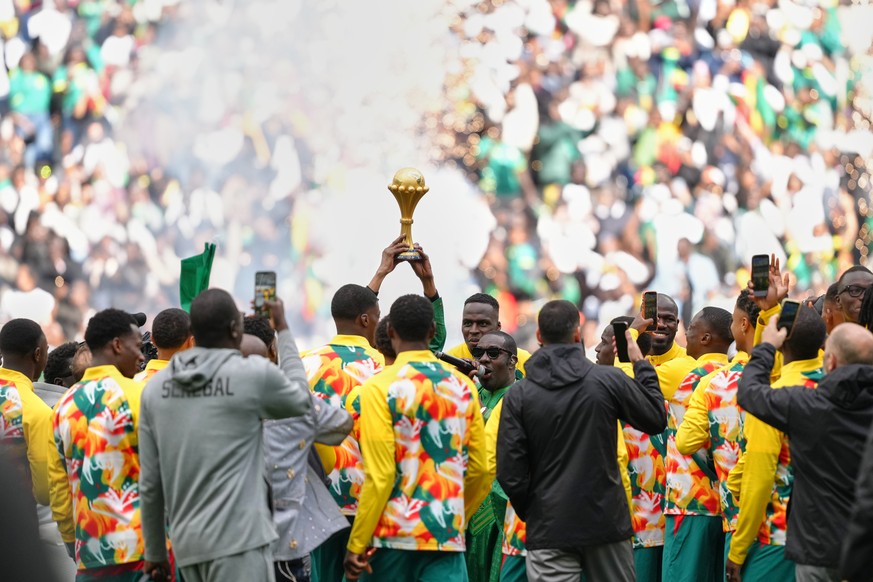 Senegal players celebrate with the Africa Cup of Nations trophy ahead of the international friendly soccer match between Senegal and Peru in Saint-Denis, outside of Paris, Saturday, March 28, 2026. (A ...
