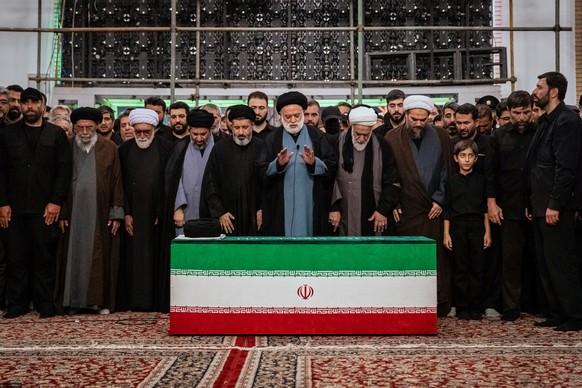Mostafa Khamenei, center, brother of Iran's new Supreme Leader Mojtaba Khamenei, leads a prayer over the coffin of his late father, Iranian Supreme Leader Ayatollah Ali Khamenei before his burial ...