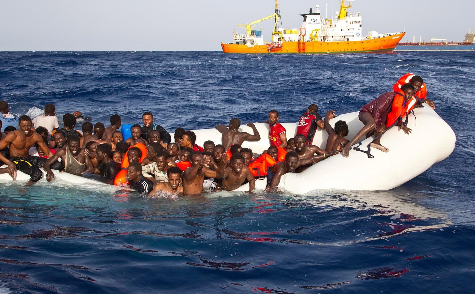 epa05265406 A handout photgraph made available by the Ong Sos Méditerranée showing migrants on a snking inflatable boat before being rescued by the Aquarius ship of the humanitarian group SOS Mediterr ...