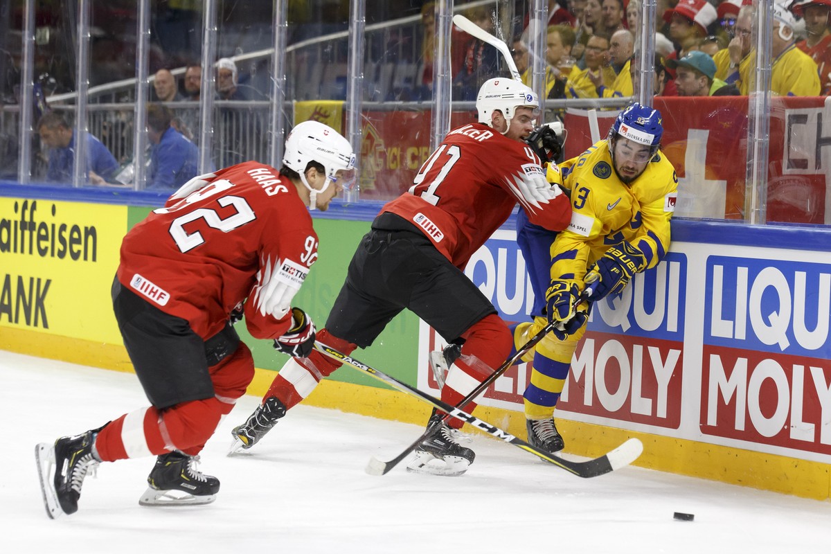 Switzerland's defender Mirco Mueller, center, checks Sweden's forward Mika Zibanejad, right, past Switzerland's forward Gaetan Haas, left, during the IIHF 2018 World Championship prelim ...