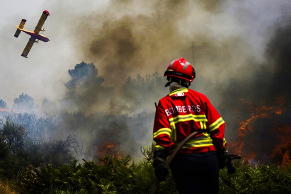 epaselect epa10072762 A firefighter fights the flames surrounding Ancede village during a wildfire in the municipality of Baiao, North of Portugal, 15 July 2022. EPA/HUGO DELGADO