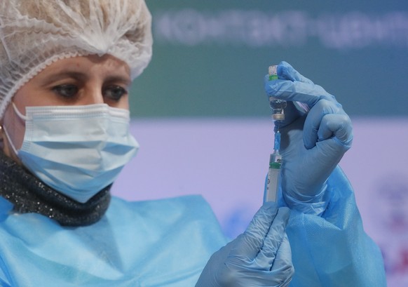 epa09078005 Ukrainian medical worker prepares a doze of AstraZeneca (Covishield) vaccine in Kiev, Ukraine, 16 March 2021 during public vaccination of medical workers and religious figures. In total, 5 ...