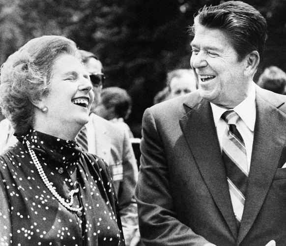 FILE - U.S. President Ronald Reagan, right, and Britain&#039;s Prime Minister Margaret Thatcher, laugh together during a break from a session at the Ottawa Summit in this file photo dated July 21, 198 ...