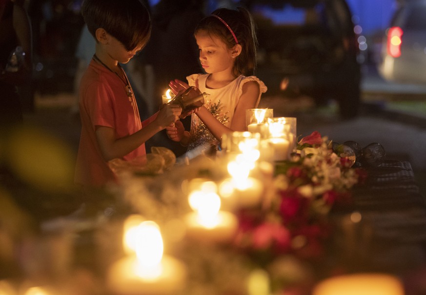 Lucrecia Martinez, 7, and her brother Luciano, 9, of Dickinson light candles during a vigil held in the wake of a deadly school shooting with multiple fatalities at Santa Fe High School on Friday, May ...