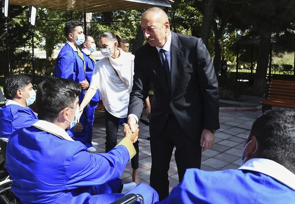 In this photo provided by the Azerbaijan&#039;s Presidential Press Office, Azerbaijani President Ilham Aliyev and his wife Mehriban Aliyeva visit the Central Military Clinical Hospital of the Defence  ...