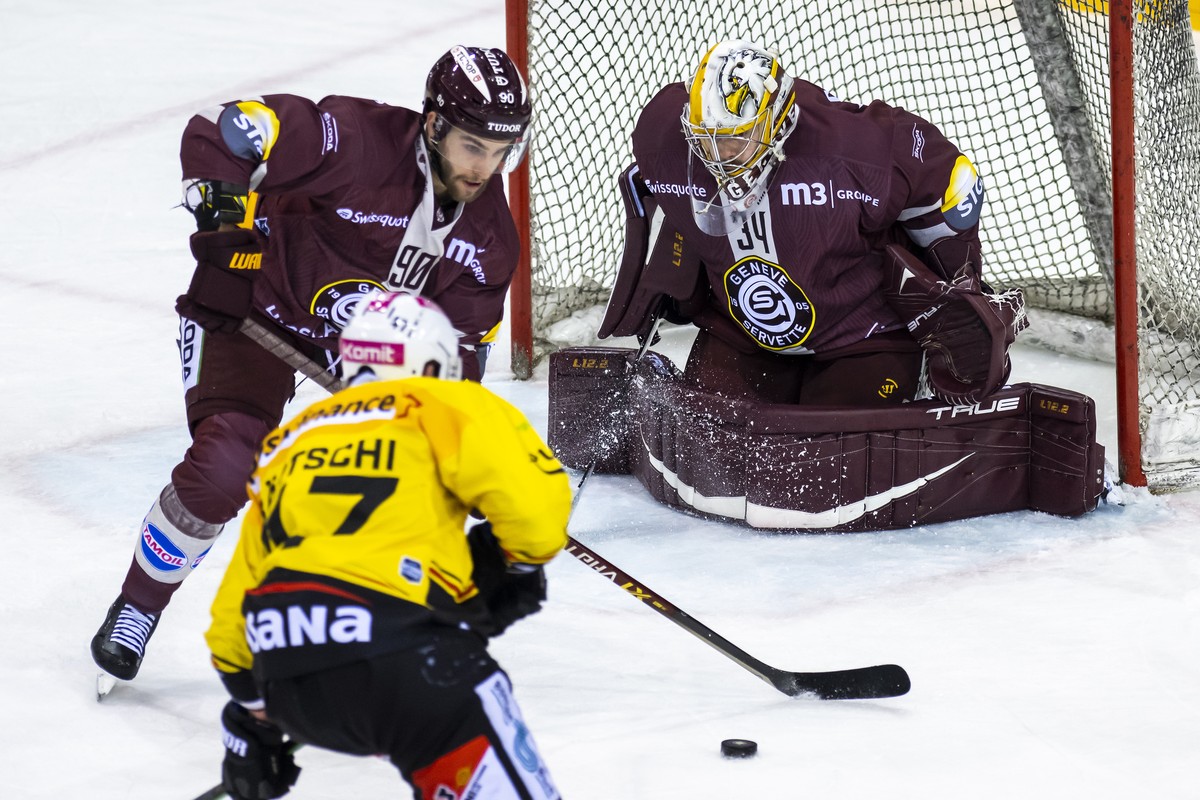 L'attaquant bernois Sven Baertschi, gauche, a la lutte pour le puck avec le defenseur genevois Simon Le Coultre, centre, devant le gardien genevois Gauthier Descloux, droite, lors du match du cha ...